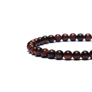 Angled view of a handmade red tiger eye bracelet emphasizing bead size and craftsmanship