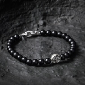 Matte black onyx bead bracelet for men with tree of life silver bead on a dark stone background